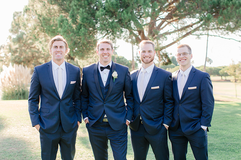 Los-Verdes-Golf-Course-Wedding-groomsmen-in-navy-blue-suits-the-groom-is-in-a-navy-blue-tuxedo-with-a-black-shawl-lapel-and-a-black-bow-tie