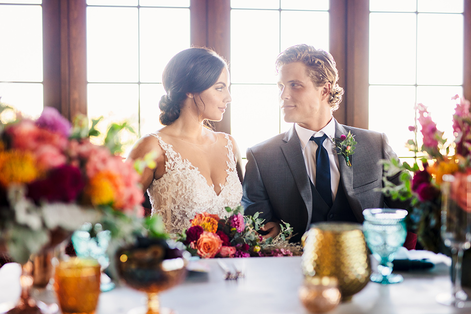 Aliso Viejo wedding design with the bride in a lace gown with thin straps and the groom in a grey suit with a blue neck tie