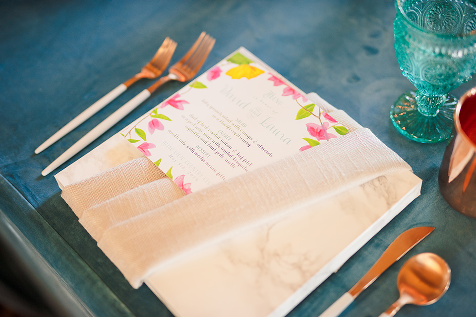 Aliso Viejo wedding design with blue crystal and colorful flowers and marble charger plates and gold flatware