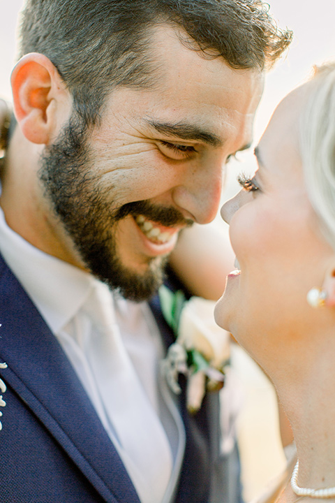 Burgundy-and-Blue-wedding-bride-and-groom-close-up-bride-in-a-white-lace-gown-with-a-sweetheart-neckline-groom-in-a-dark-blue-suit-with-a-white-neck-tie