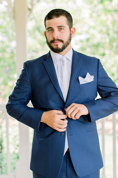 Burgundy-and-Blue-wedding-groom-buttoning-jacket