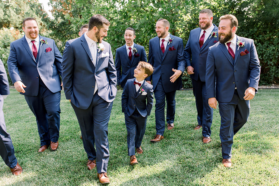 Burgundy-and-Blue-wedding-groomsmen-walking-groomsmen-in-dark-blue-suits-the-groom-is-in-a-dark-blue-suit-with-an-ivory-long-tie