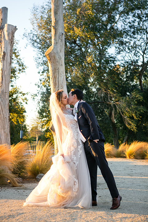 Garden-Wedding-bride-and-groom-dancing-bride-in-a-strapless-ballgown-with-her-hair-down-in-a-loose-wave-groom-in-a-navy-suit-with-a-white-long-tie-and-pink-pocket-square