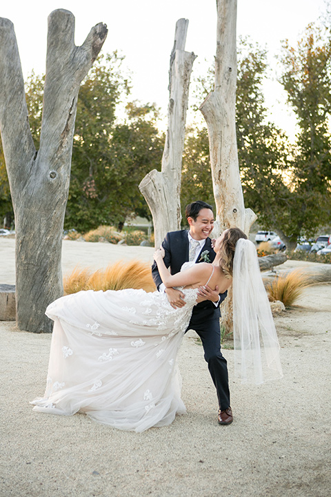 Garden-Wedding-groom-dipping-bride-bride-in-a-strapless-ballgown-with-her-hair-down-in-a-loose-wave-groom-in-a-navy-suit-with-a-white-long-tie-and-pink-pocket-square