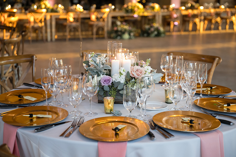 Garden-Wedding-table-decor-drapping-fabrics-and-wooden-table-and-chairs-and-gold-plates-with-pink-napkins