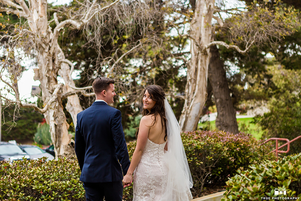 Bride and groom pose for a photo while walking