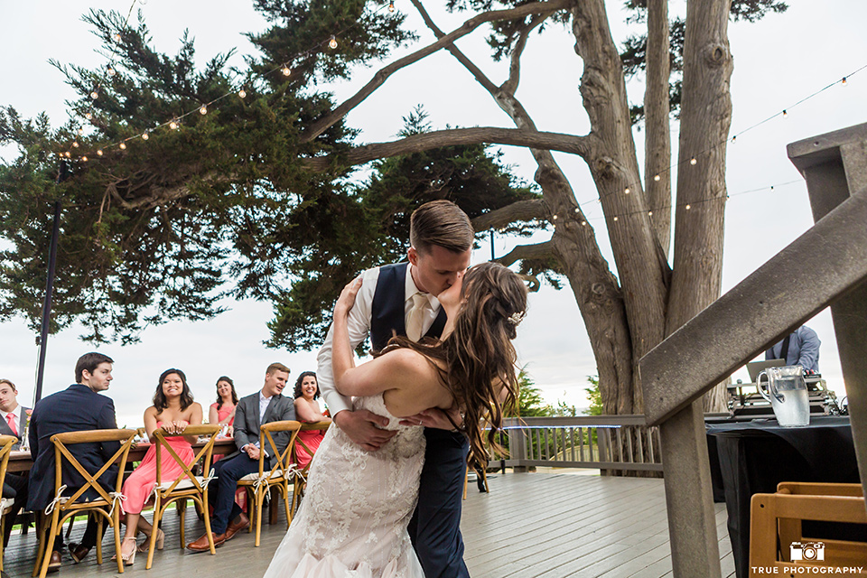 Bride and groom kiss during first dance at wedding