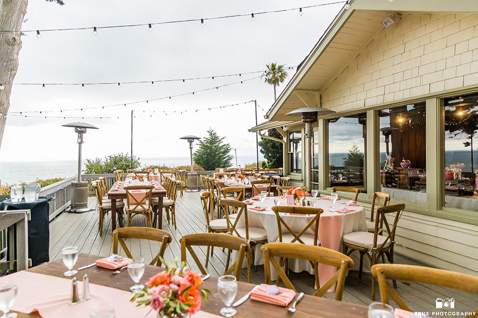 La Jolla wedding reception venue with wooden picnic tables and coral details