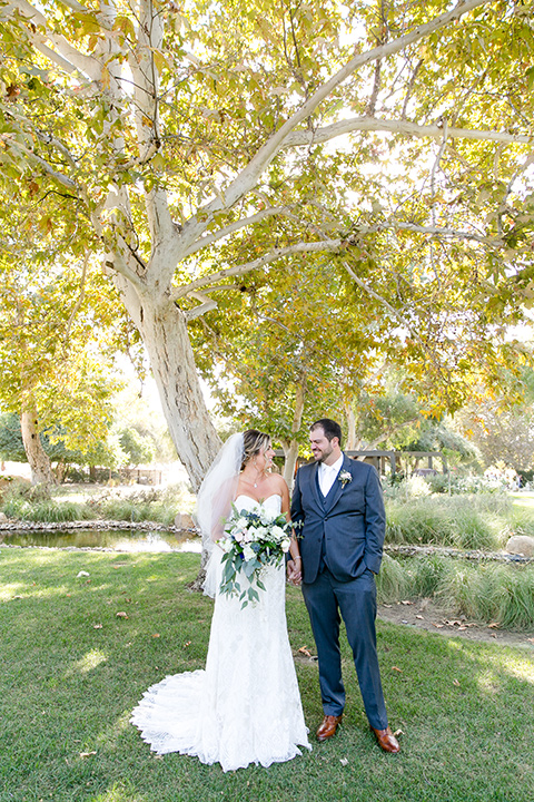 gallaway-downs-wedding-bride-and-groom-looking-at-each-other-bride-in-a-lace-a-line-gown-with-a-sweetheart-neckline-and-the-groom-in-a-dark-blue-suit-with-a-white-long-tie