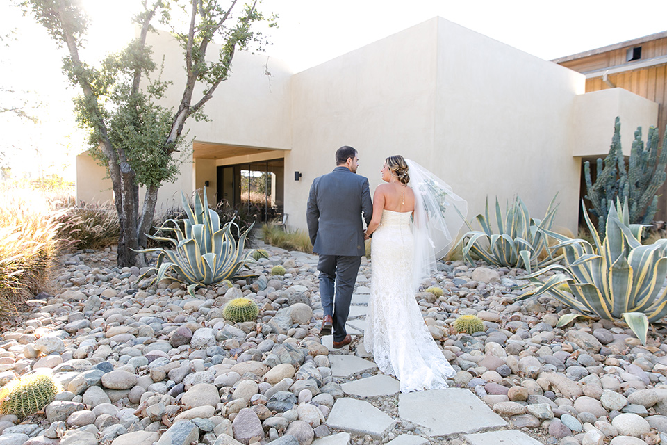 gallaway-downs-wedding-bride-and-groom-walking-away-bride-in-a-lace-a-line-gown-and-groom-in-a-navy-blue-suit-with-a-white-long-tie