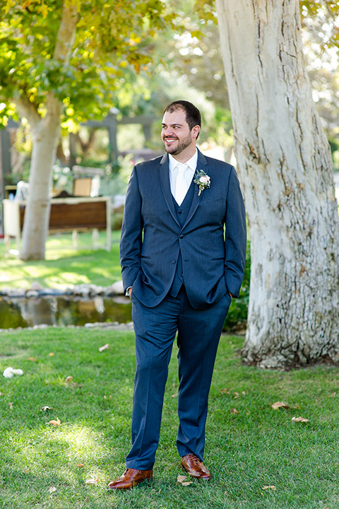 gallaway-downs-wedding-groom-look-to-the-side-in-a-dark-blue-suit-with-a-white-long-tie