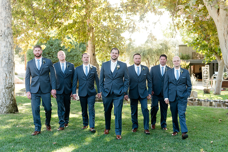 gallaway-downs-wedding-groomsmen-walking-in-navy-blue-suits-bride-in-a-lace-a-line-gown-and-groom-in-a-navy-blue-suit-with-a-white-long-tie