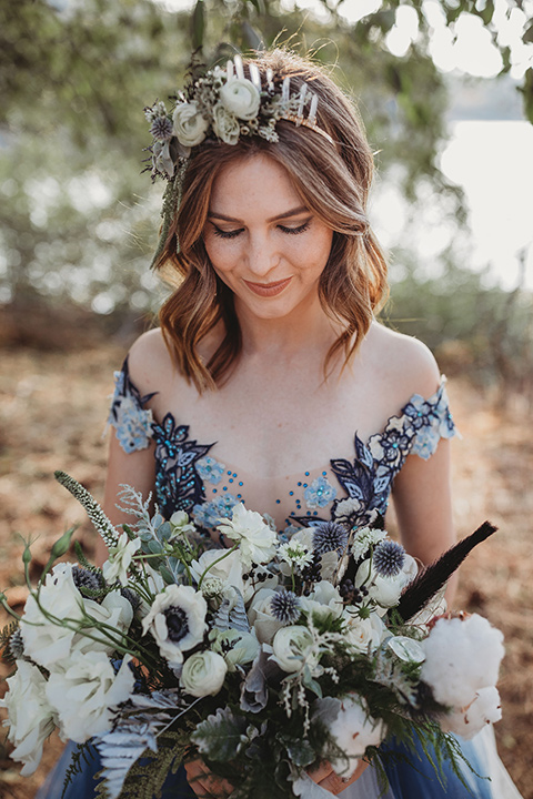 Big-Bear-Elopement-Shoot-bride-holding-flowers-gown-with-an-illusion-neckline-and-floral-design-the-groom-wore-a-traditional-black-tuxedo-with-a-peak-lapel-and-black-bow-tie