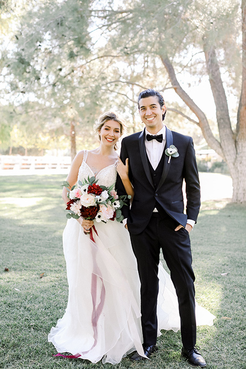 bride and groom pose for a wedding photo facing the camera