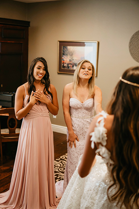 boho elopement shoot with the bride in a lace ball gown and a gold chair headpiece and the bridesmaids in pink gowns