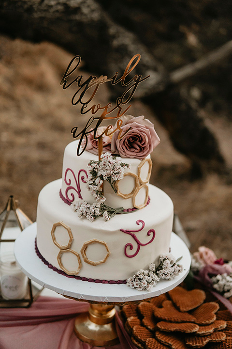 two tiered cake with white icing and blush toned decor