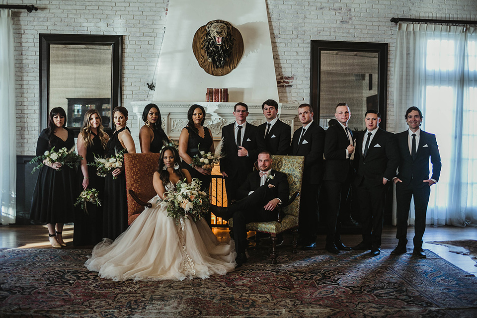 The-Ebell-In-Long-Beach-Wedding-bridalparty-bridesmaids-in-black-dresses-groomsmen-in-black-tuxeds-with-black-long-ties-bride-in-a-champagne-ballgown-with-a-strapless-neckline-and-the-groom-in-a-black-tuxedo-with-a-rose-gold-bow-tie