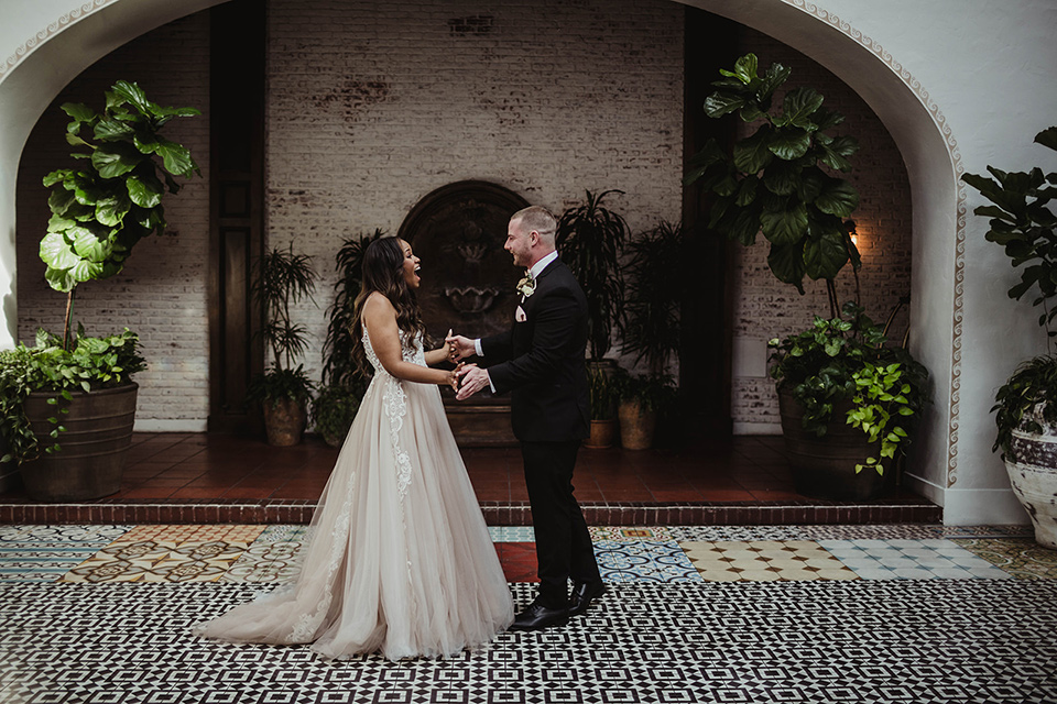The-Ebell-In-Long-Beach-Wedding-bride-and-groom-first-look-bride-in-a-champagne-ballgown-with-a-strapless-neckline-and-the-groom-in-a-black-tuxedo-with-a-rose-gold-bow-tie