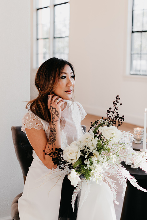 Building-177-Styled-Shoot-bride-looking-out-the-window-in-a-flowing-white-gown-with-short-sleeves-and-beading-detail