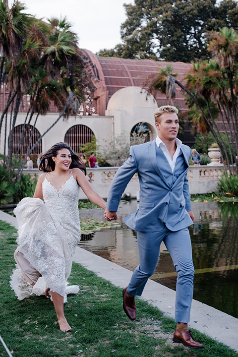 California Dreaming Shoot bride and groom running bride in a form fitting lace gown with thin straps groom in a light blue suit