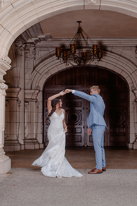 California Dreaming Shoot bride and groom spinning bride in a form fitting lace gown with thin straps groom in a light blue suit