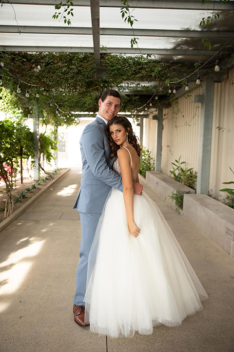 Callaway-Styled-Shoot-bride-and-groom-embracing-bride-in-a-tulle-ballgown-with-a-colorful-beaded-bodice-groom-in-a-light-blue-suit