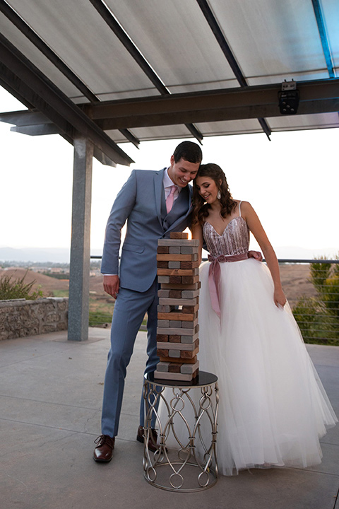 Callaway-Styled-Shoot-bride-and-groom-playing-jenga-bride-in-a-tulle-ballgown-with-a-colorful-beaded-bodice-groom-in-a-light-blue-suit