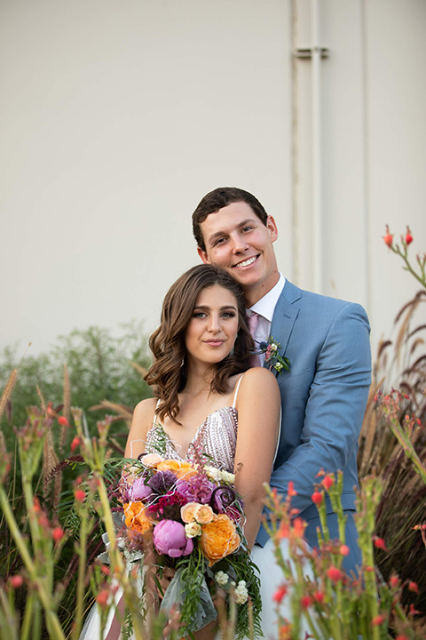 Callaway-Styled-Shoot-bride-and-groom-smiling-at-camera-bride-in-a-tulle-ballgown-with-a-colorful-beaded-bodice-groom-in-a-light-blue-suit