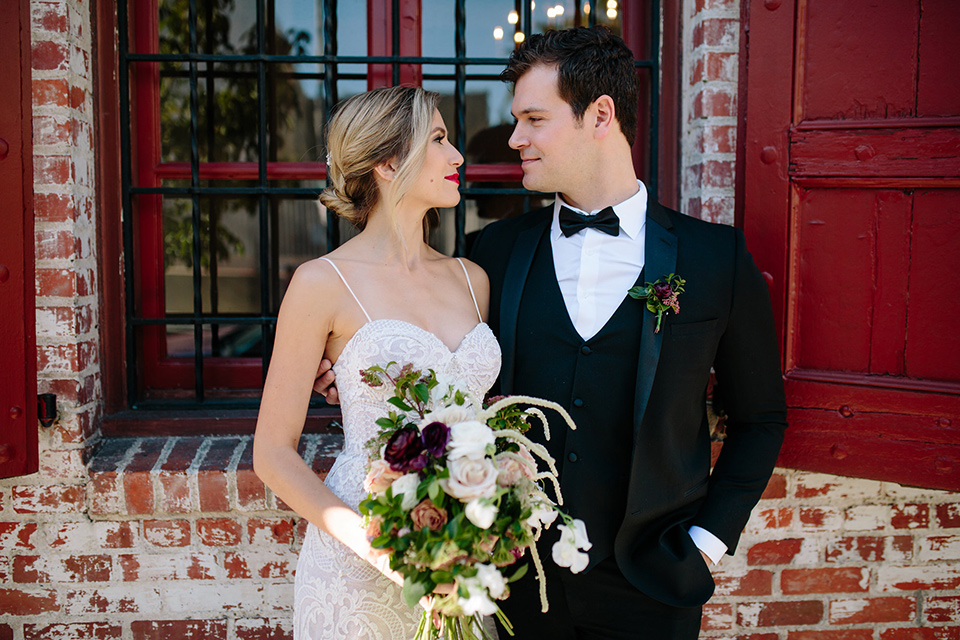 Carondelet-House-wedding-bride-and-groom-looking-at-each-other-bride-in-a-lace-gown-with-an-illusion-neckline-and-thin-straps-groom-in-a-traditional-black-tuxedo-with-a-black-bow-tie