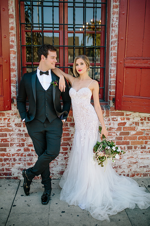 Carondelet-House-wedding-bride-and-groom-standing-facing-camera-bride-in-a-lace-gown-with-an-illusion-neckline-and-thin-straps-groom-in-a-traditional-black-tuxedo-with-a-black-bow-tie