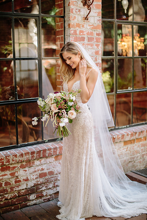 Carondelet-House-wedding-bride-by-windows-bride-and-groom-at-bride-in-a-lace-gown-with-an-illusion-neckline-and-thin-straps