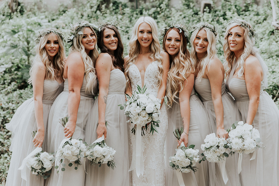 rancho-las-lomas-real-wedding-bridesmaids-close-the-bride-is-in-a-lace-long-gown-with-a-deep-v-and-straps-and-the-bridesmaids-in-taupe-long-gowns