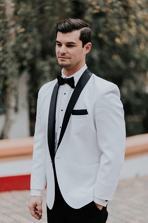 rancho-las-lomas-real-wedding-groom-standing-in-a-white-tuxedo