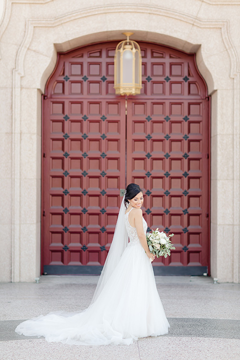 kellogg-house-pomona-wedding-bride-looking-over-shoulder-bride-in-a-lace-mermaid-gown-with-a-high-neckline