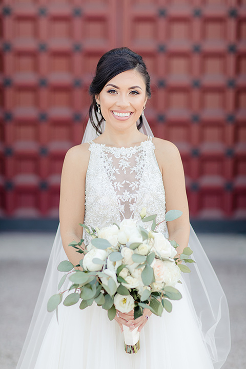 kellogg-house-pomona-wedding-bride-smiling-at-camera-in-a-lace-white-gown-with-a-high-neckline-and-a-mermaid-style-skirt