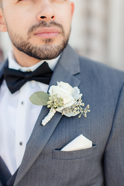 kellogg-house-pomona-wedding-close-up-on-groom-attire-in-a-dark-grey-tuxedo-with-a-black-bow-tie