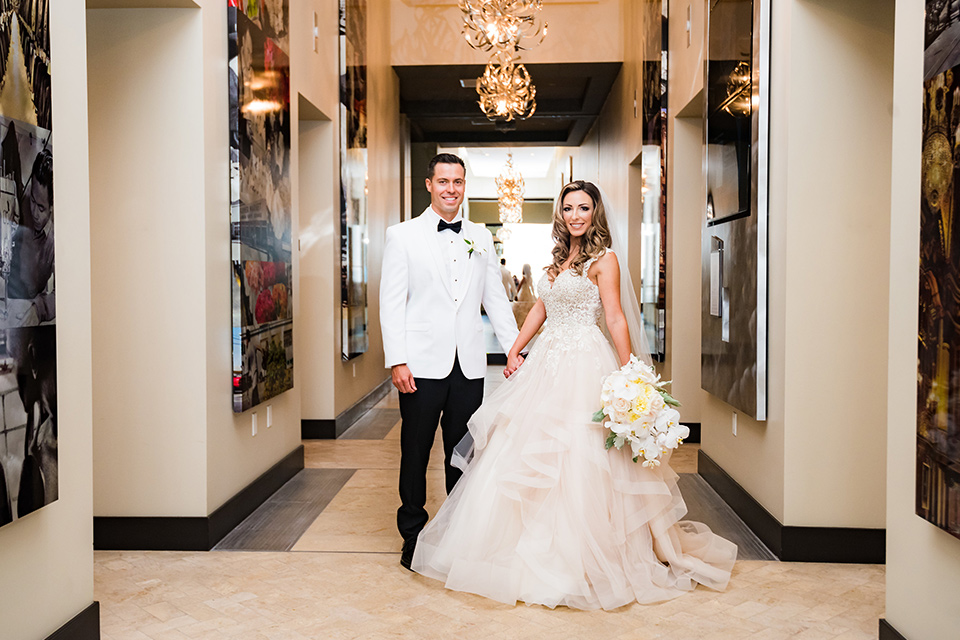 City-club-shoot-bride-and-groom-in-hallway-bride-in-a-white-ballgown-with-a-sweetheart-neckline-and-straps-groom-in-a-white-coat-with-black-pants