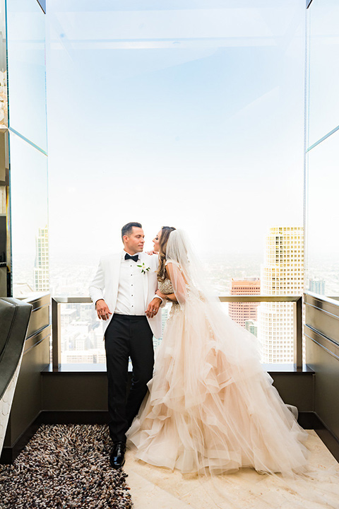 City-club-shoot-bride-and-groom-looking-in-different-directions-bride-in-a-white-ballgown-with-a-sweetheart-neckline-groom-in-a-white-jacket-with-black-pants