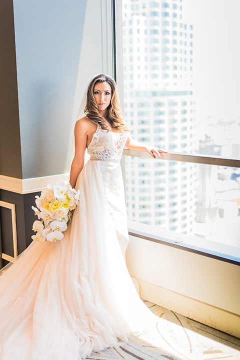 City-club-shoot-bride-looking-at-camera-bride-in-a-white-ballgown-with-straps-and-a-sweetheart-neckling-groom-in-a-white-coat-with-black-pants