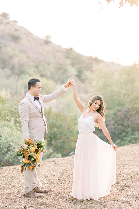 Claudia+Johns-meadow-elopement-bride-and-groom-dancing-bride-in-a-two-toned-gown-with-a-blush-skirt-with-a-white-silk-top-and-the-groom-in-a-tan-suit-with-a-deep-brow-bow-tie