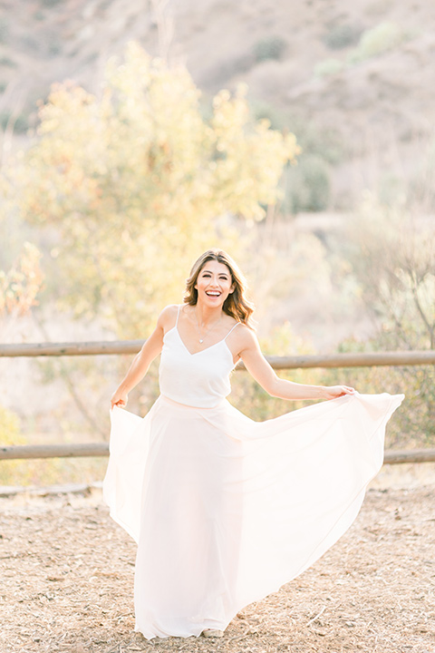 Claudia+Johns-meadow-elopement-bride-holding-florals-bride-in-a-two-toned-gown-with-a-light-pink-sjirt-and-a-white-silk-top