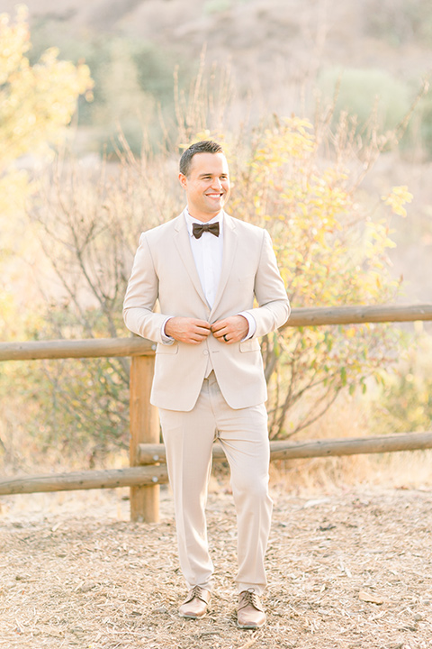 Claudia+Johns-meadow-elopement-groom-groom-is-in-a-tan-suit-with-a-deep-brown-bow-tie