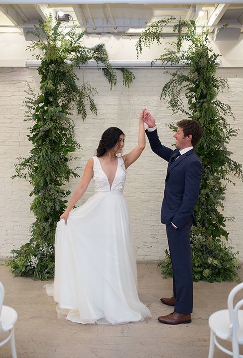 Cooks-Chapel-Shoot-bride-and-groom-dancing-the-bride-is-in-a-white-long-flowing-gown-with-a-deep-v-neckline-while-the-groom-is-in-a-dark-blue-suit-with-a-navy-long-tie