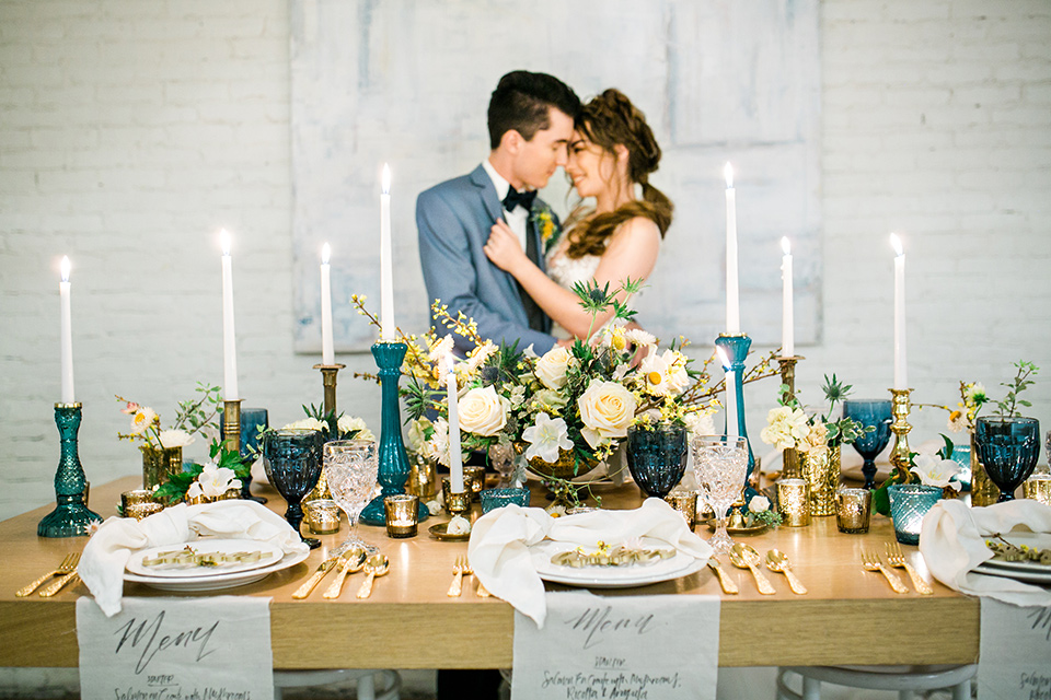 Wedding bride and groom sitting at the table inside Cooks Chapel at the Anaheim packing house decorated with candles and flowers