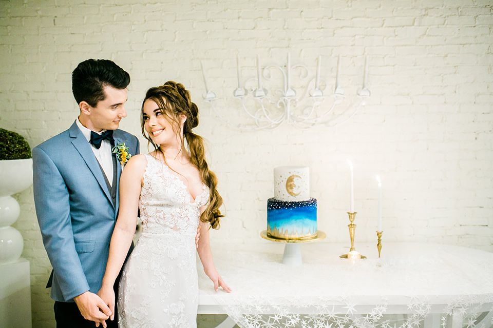 Wedding bride and groom with cake at the table over a white lace tablecloth
