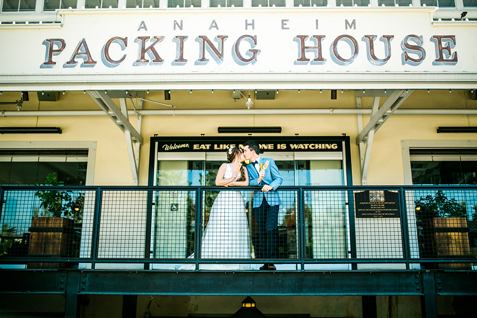 Wedding bride and groom kiss with popsicles in hand outside of the anaheim packing house