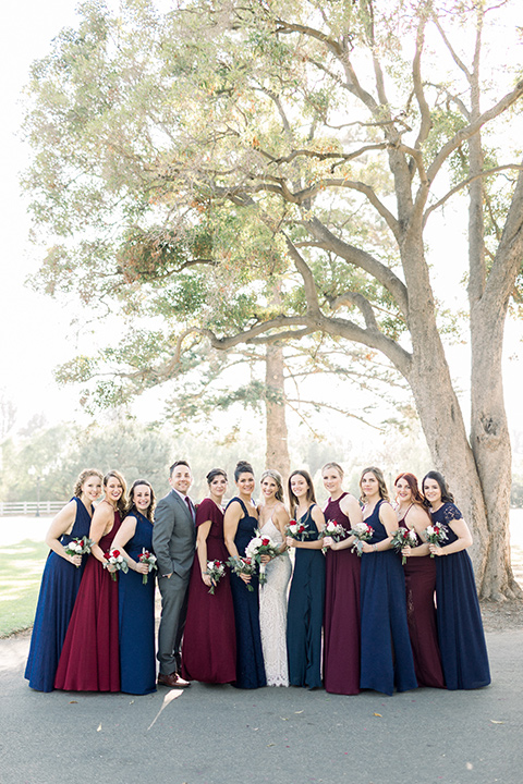 red-barn-wedding-bridesmaids-bridesmaids-in-alternating-navy-and-burgundy-dresses-groomsmen-in-grey-suits-bride-in-a-lace-fitted-dress-with-thin-straps-groom-in-a-blue-suit-with-grey-vest-and-burgundy-tie