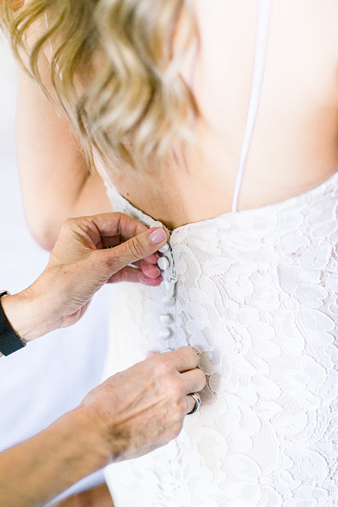 red-barn-wedding-buttons-on-dress-bride-in-a-lace-fitted-dress-with-thin-straps-groom-in-a-blue-suit-with-grey-vest-and-burgundy-tie