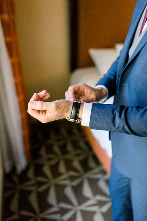 red-barn-wedding-chris-fixing-his-watch-groom-in-a-blue-suit-with-grey-vest-and-burgundy-tie