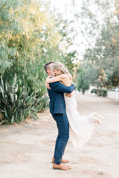 red-barn-wedding-groom-picking-up-bride